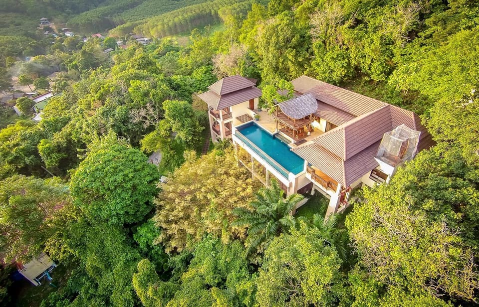 Aerial view of the villa nestled in the rainforest above the bay