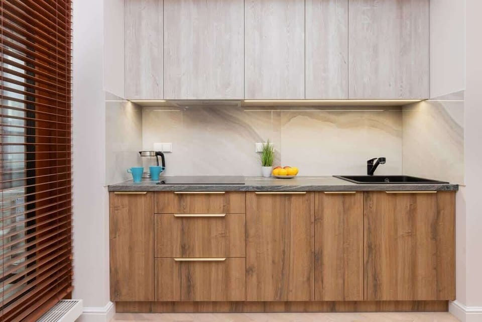 A built-in wooden cabinet housing a black oven, offering a sleek finish and maintaining the kitchen’s contemporary aesthetic.







