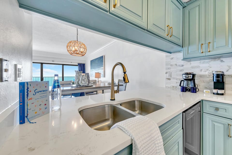 Your elegant coastal kitchen awaits with gleaming quartz counters, gulf views, and coffee ready for perfect mornings by the sea.