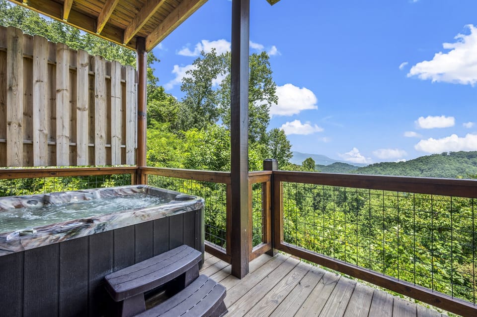 The hot tub is located on the lower deck of the cabin.