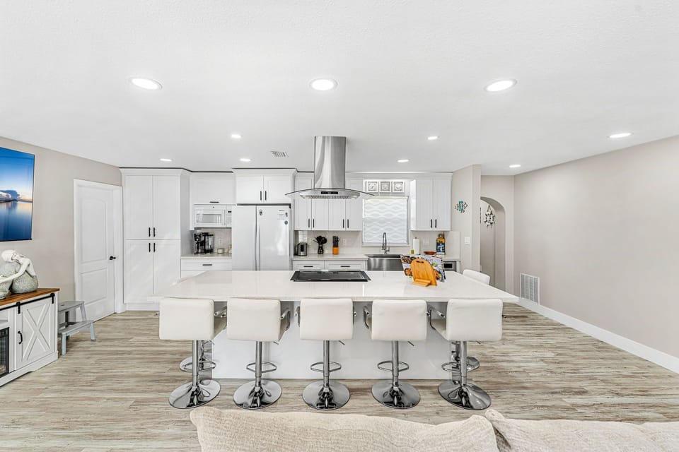 Kitchen with sleek countertops and stools, perfect for casual dining or quick meals.