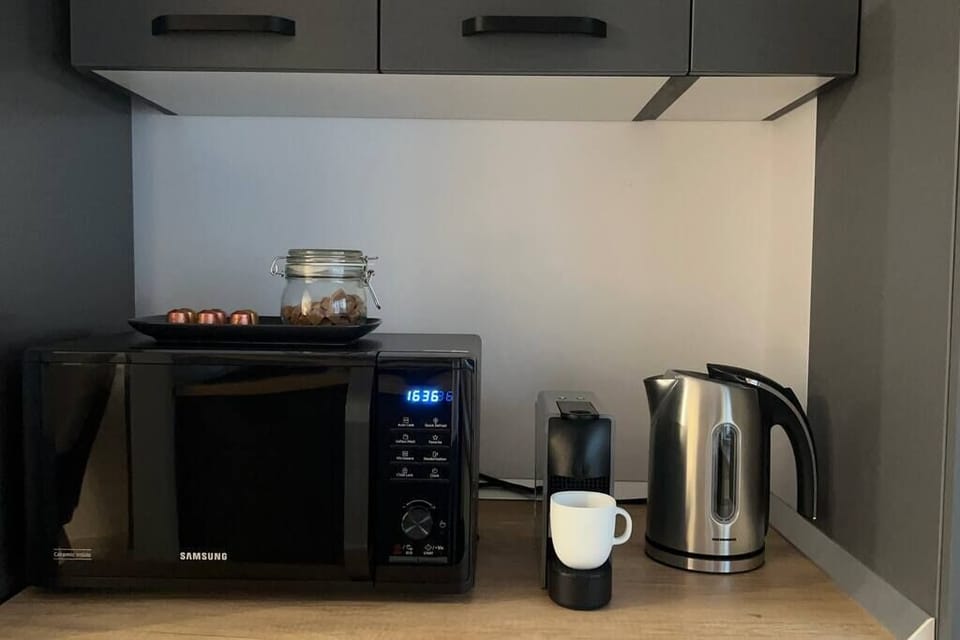 Kitchen equipped with microwave, electric kettle, coffee machine, refrigerator