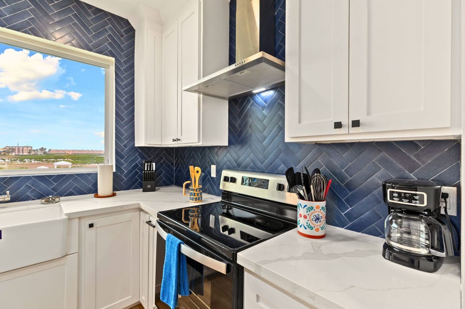 Enjoy cooking in a beautifully designed kitchen with a spacious island, modern finishes, and all the cookware and essentials to make you feel right at home.