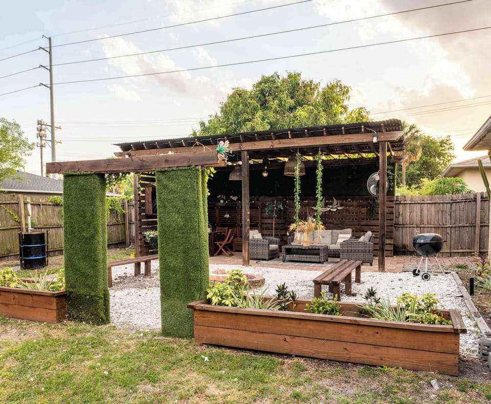 Outdoor living space equipped with Smart TV, Outdoor Grill, Smoker, dining area, appropriate lighting and fans
