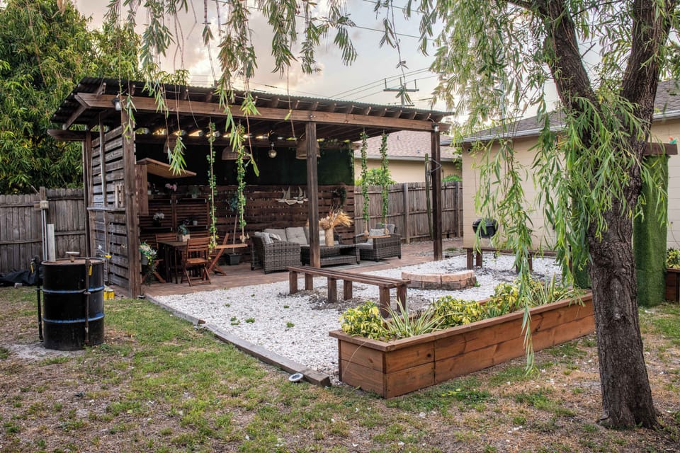 Outdoor living space equipped with Smart TV, Outdoor Grill, Smoker, dining area, appropriate lighting and fans