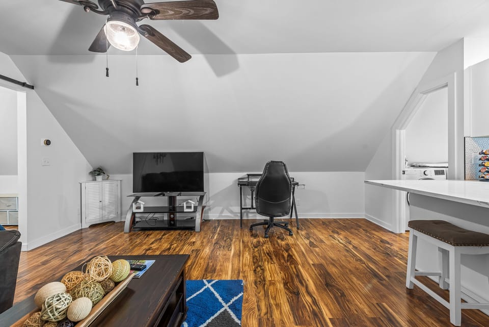 Unwind in your private loft space with vaulted ceilings, rich hardwood floors, and modern amenities for work or relaxation.