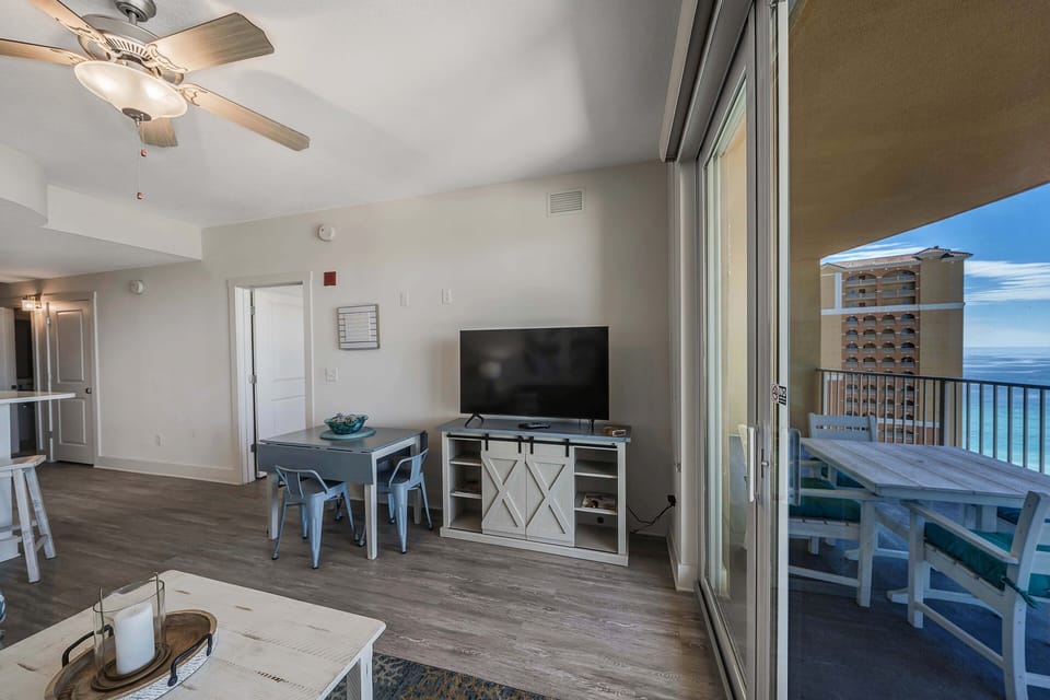 The living room offers ample, comfortable seating with a large smart television with Direct TV and doors leading to the unit's spacious private balcony with breathtaking views.
