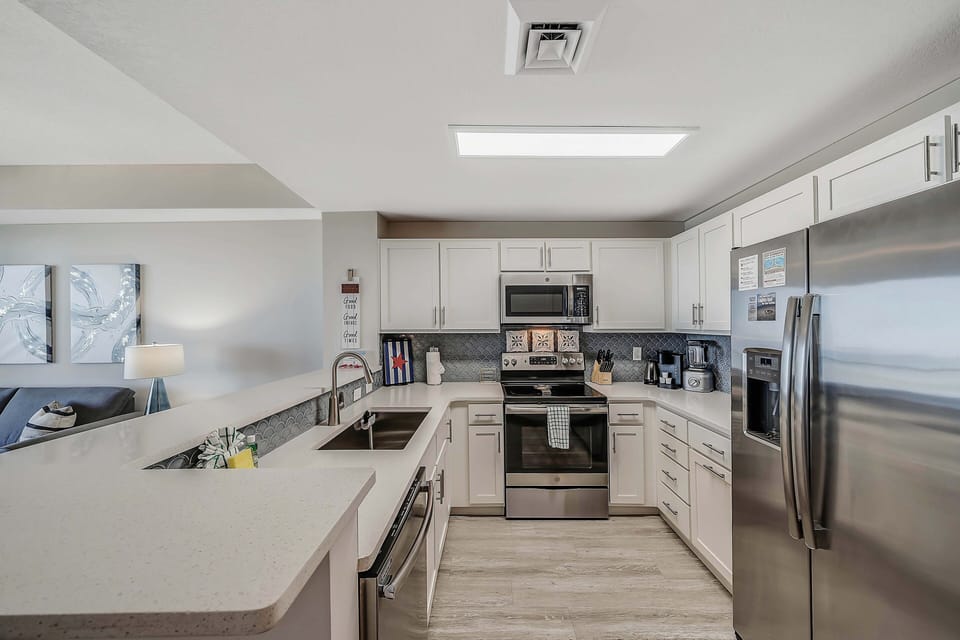 The fully equipped kitchen features quartz countertops and stainless-steel appliances.