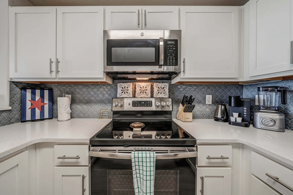 The fully equipped kitchen features quartz countertops and stainless-steel appliances.