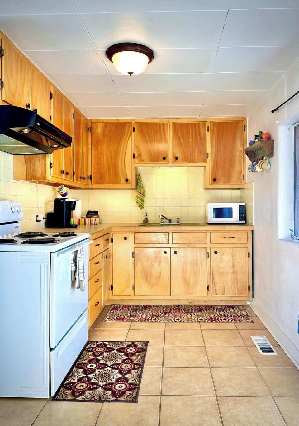 Full kitchen with electric range and oven as well as a full sized refrigerator 