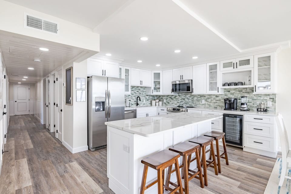 Barstools in the kitchen island provide a sweet spot for morning hot beverages, breakfast, snacks, and lunch.