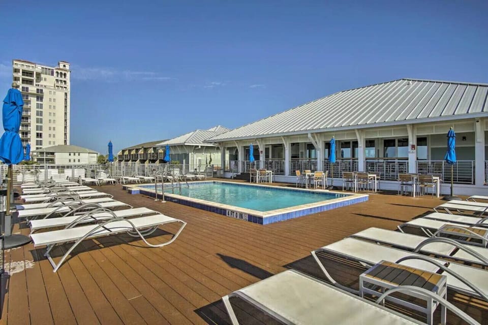 Sparkling pool with plenty of comfortable lounge chairs and shaded umbrellas, perfect for soaking up the sun.