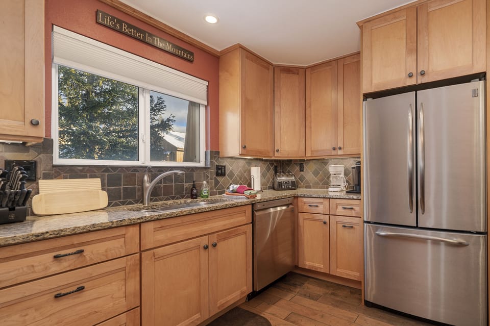 - Charming kitchen with wood cabinetry, granite counters, and full stainless appliances - Tree framed window over the sink adds calm and character to cooking time - Includes all the essentials to prep your favorite dishes with ease