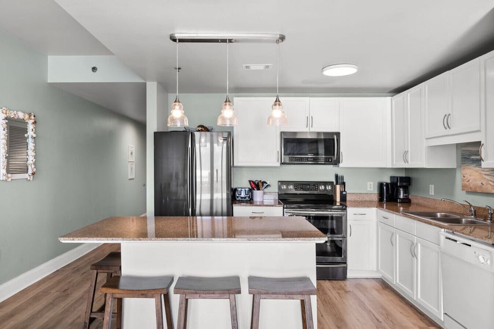 Updated kitchen with stainless steel appliances, ample storage, and a generous island perfect for cooking and gathering.