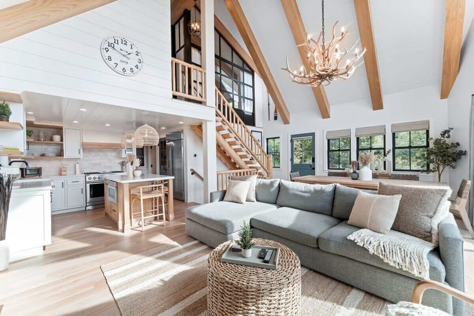 A bright open concept  living space with fireplace, smart  TV and views.