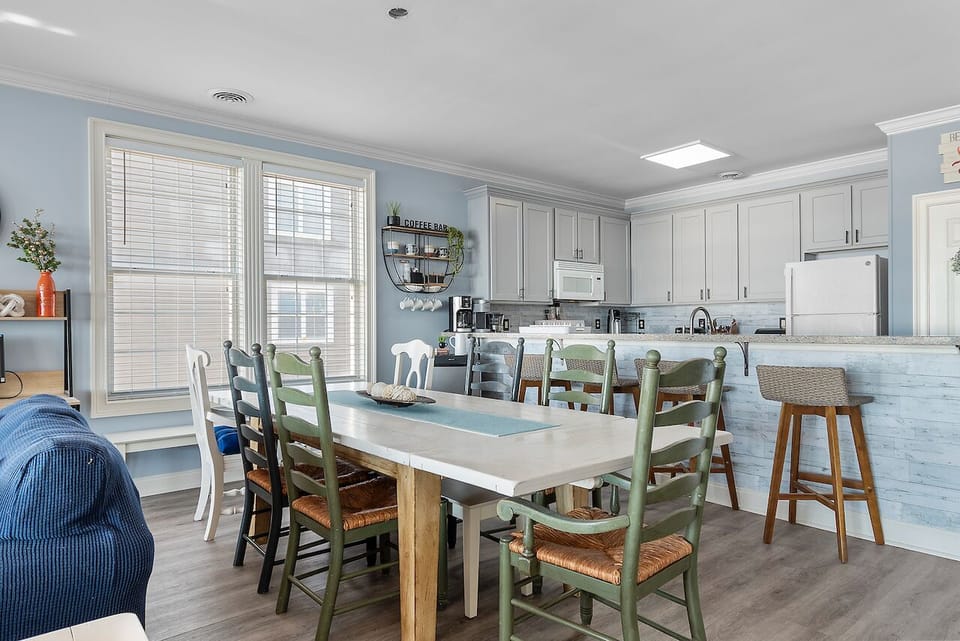 Gather around this inviting dining table where your group can share meals and create memories in the bright, open kitchen space.