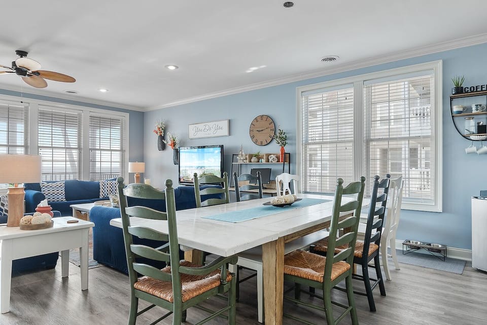 Gather around your coastal dining table where morning coffee flows into evening conversations, all beneath soothing blue walls.