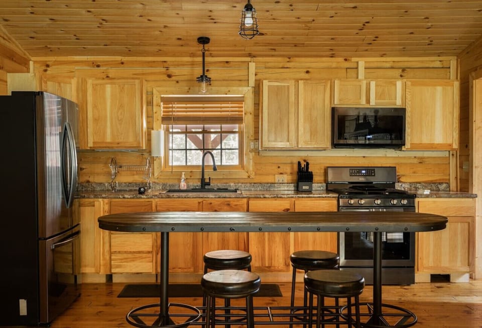 Fully equipped for your culinary adventures, this open-concept kitchen allows you to cook while staying connected to the heart of the cabin.