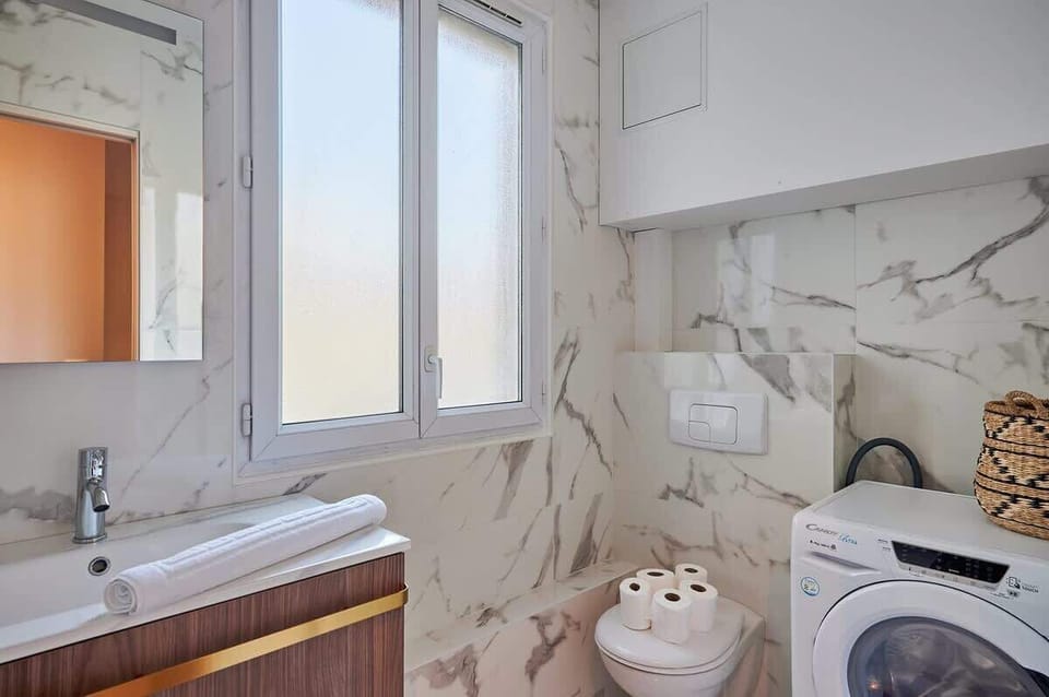 Salle de bain avec toilette et machine à laver