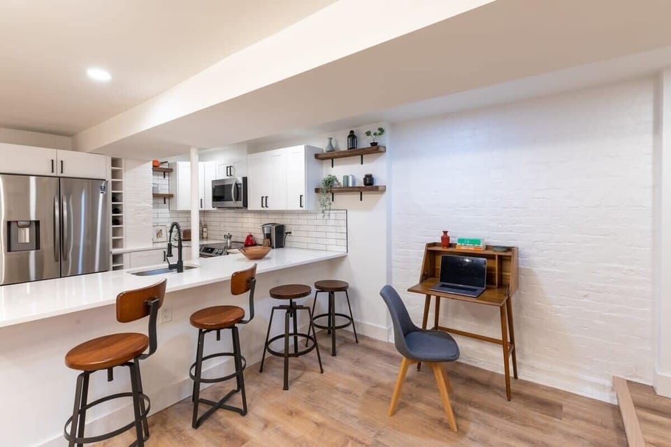 Living room with a view of the desk, bar stools, and the kitchen. 