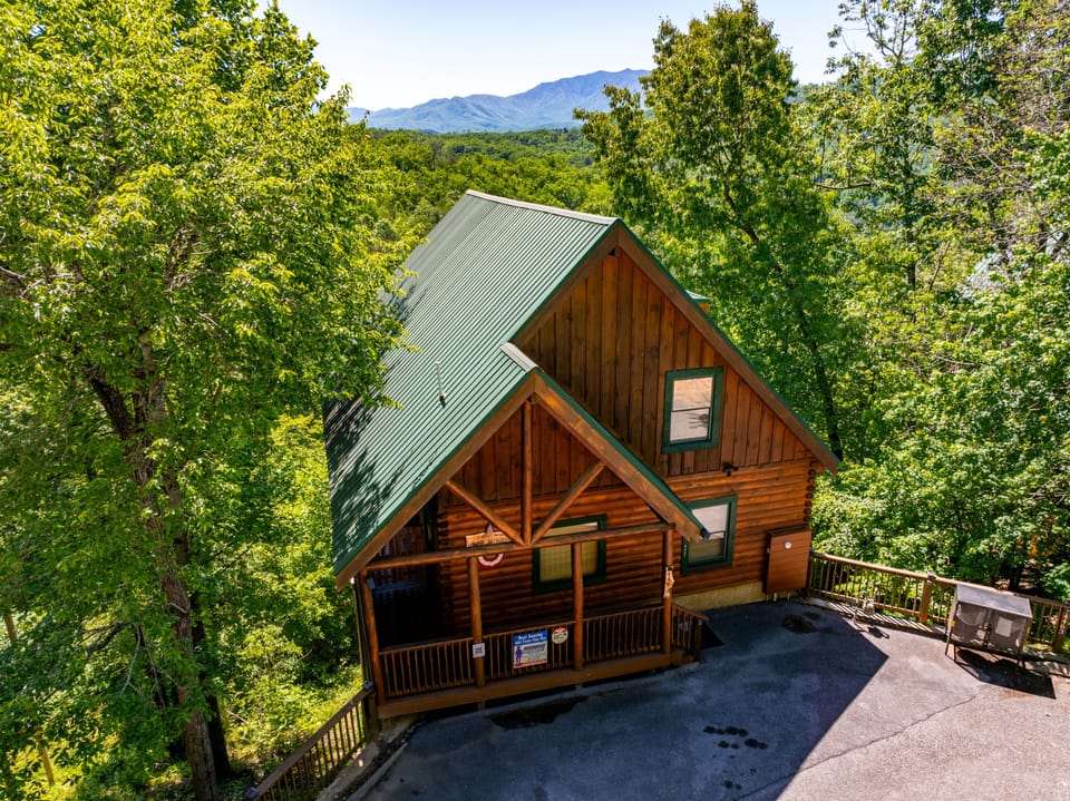 Nestled in lush forest with stunning mountain views, this charming log cabin offers a peaceful retreat surrounded by nature's beauty and tranquil woodland serenity.