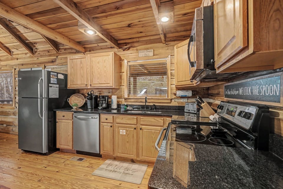 Your fully-equipped kitchen invites cozy cooking adventures with rustic wood beams, granite counters, and stainless steel appliances.