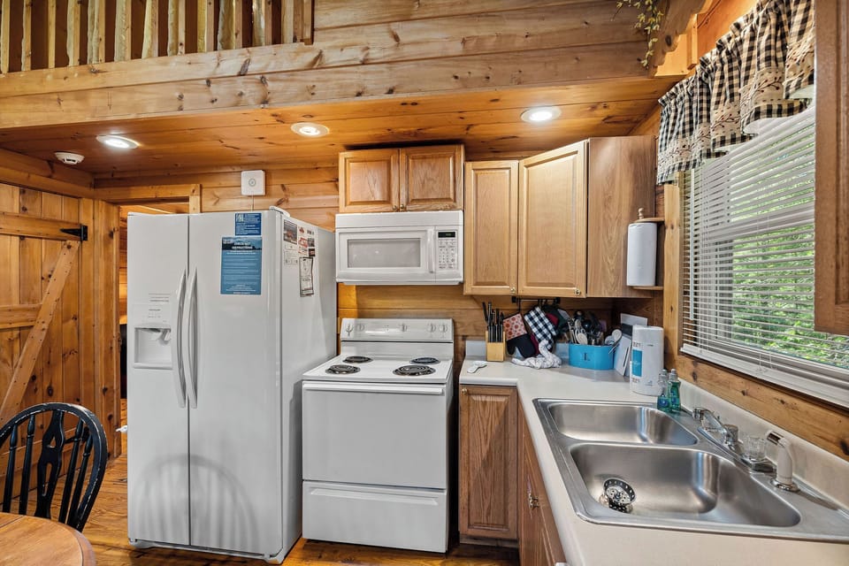 Kitchen with white appliances at Cloud 9, a 1-bedroom cabin rental located in Pigeon Forge