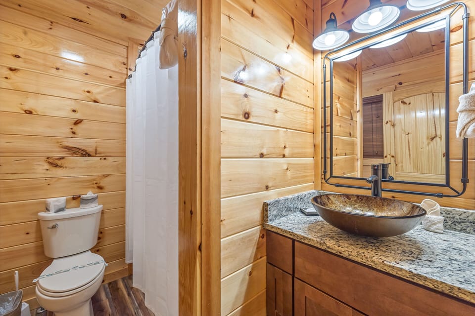 Bathtub with divider wall to single vanity sink