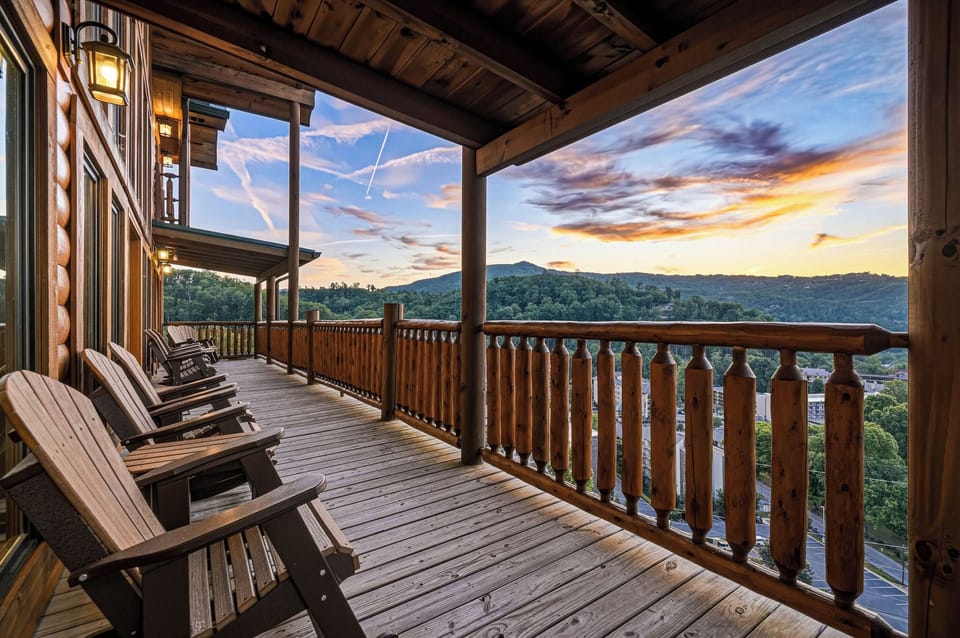 A covered deck overlooking rolling mountains at sunset—complete with rocking chairs for your evening relaxation and mountain views that stretch for miles.