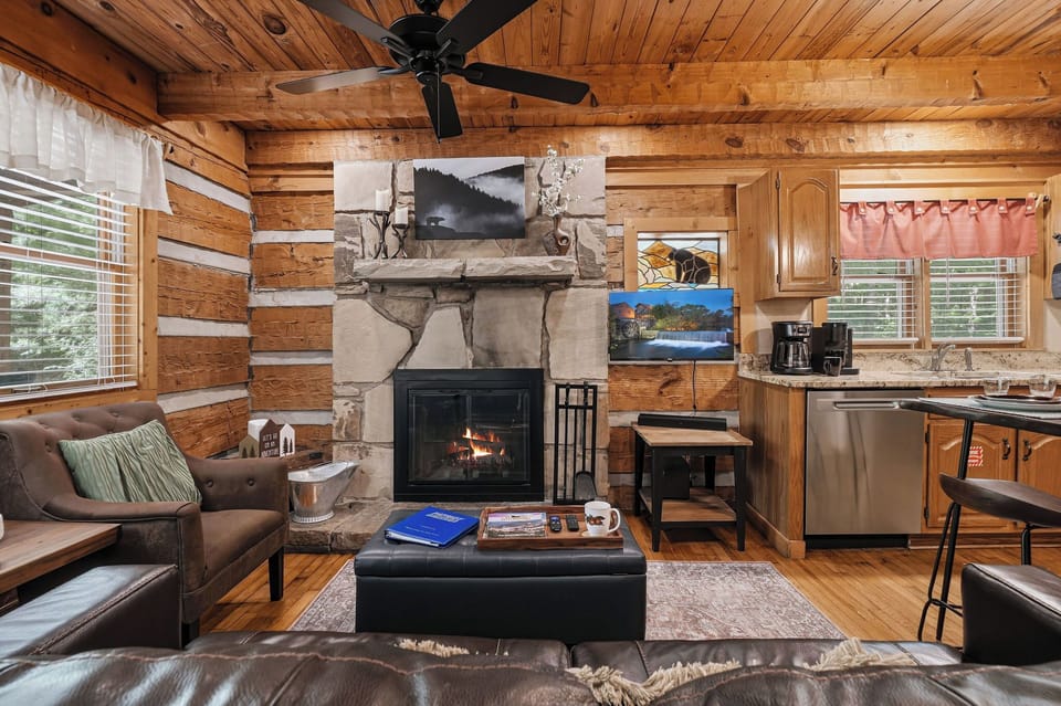 Curl up in your own rustic retreat with vaulted wood-beamed ceilings and a glowing stone fireplace. The open layout blends living, dining, and kitchen space so you can unwind completely.