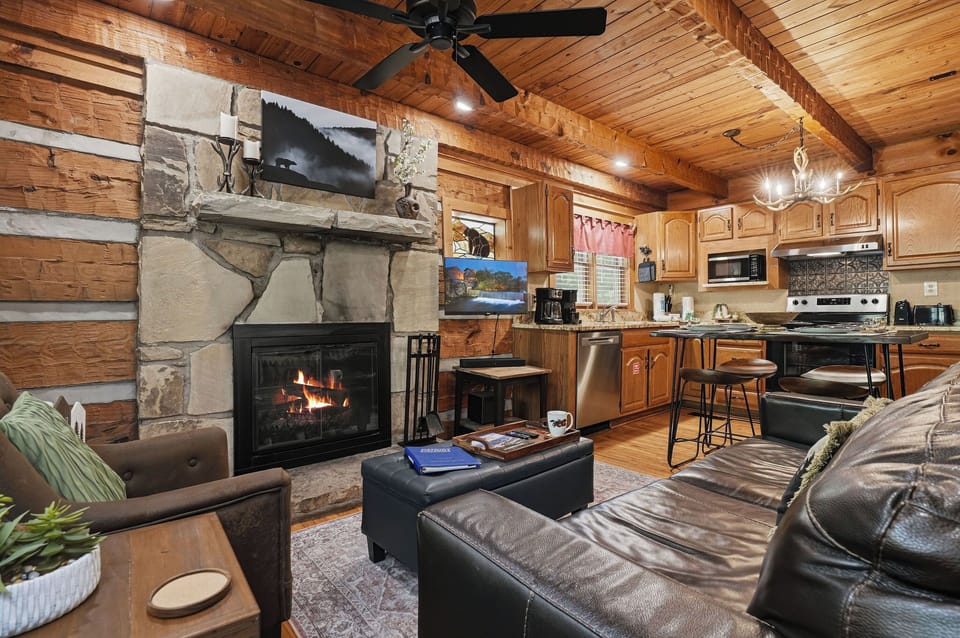 Warm wood tones surround you as you relax by the stone fireplace, while the fully-equipped kitchen awaits your culinary adventures in this inviting open-concept cabin.