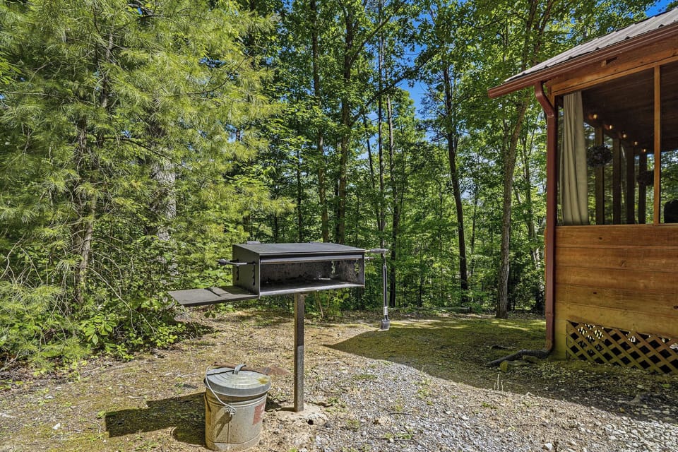 Nestled among towering trees, the property's grilling area invites you to enjoy outdoor cooking in a tranquil, forested setting.