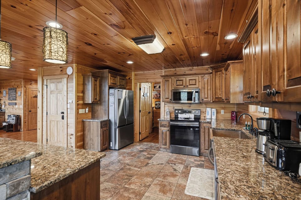 Step into your fully equipped kitchen with granite counters, modern appliances, and warm wood finishes that make meal prep a pleasure during your stay.