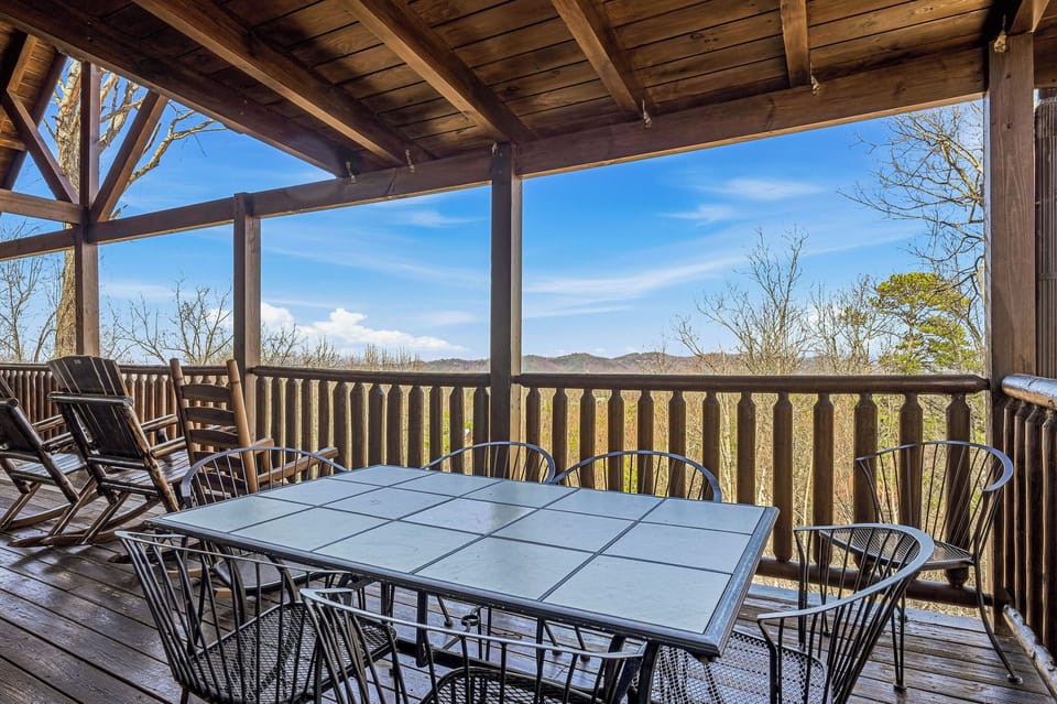 Covered deck with mountain views where you'll savor morning coffee and evening meals while watching seasons change across rolling hills.