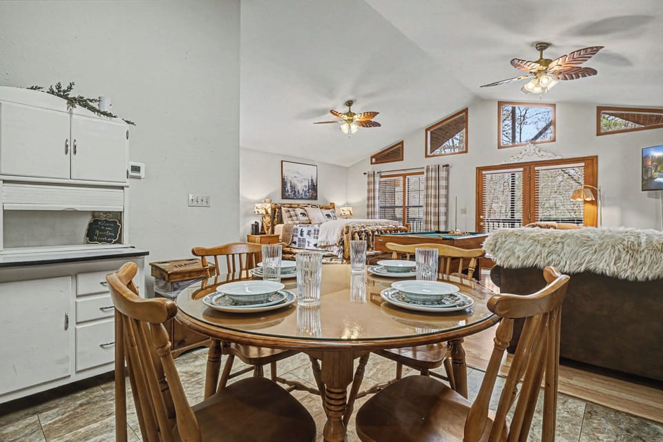 Gather around your warm wooden dining table while cozy ceiling fans circulate the air above your fully-equipped kitchen and plush living space.