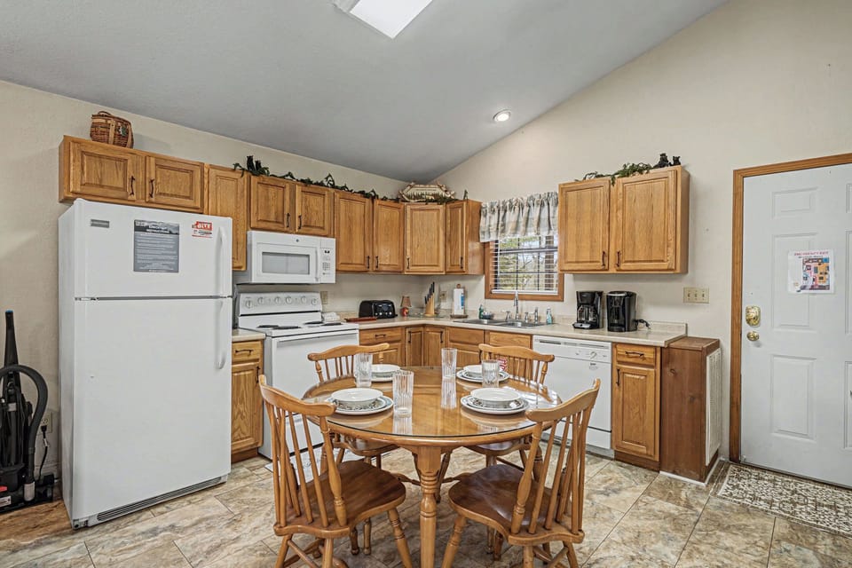 Your fully equipped kitchen invites home-cooked meals with warm wood cabinets and a charming dining table for memorable gatherings.