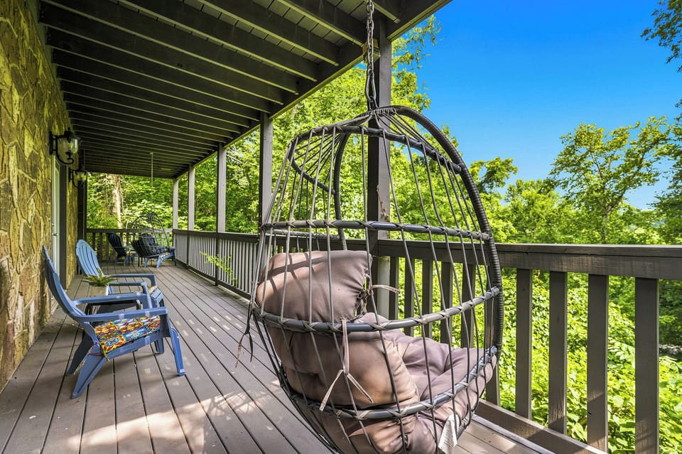 Relax in the hammock chair on your private deck, surrounded by lush tree canopy and summer sky—your peaceful escape awaits.