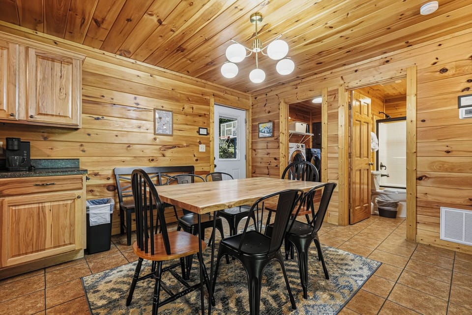 Gather around the natural wood table in this warm, welcoming cabin-style dining area for meals and memories together. The cozy knotty-pine interior and ample seating make every gathering feel special.