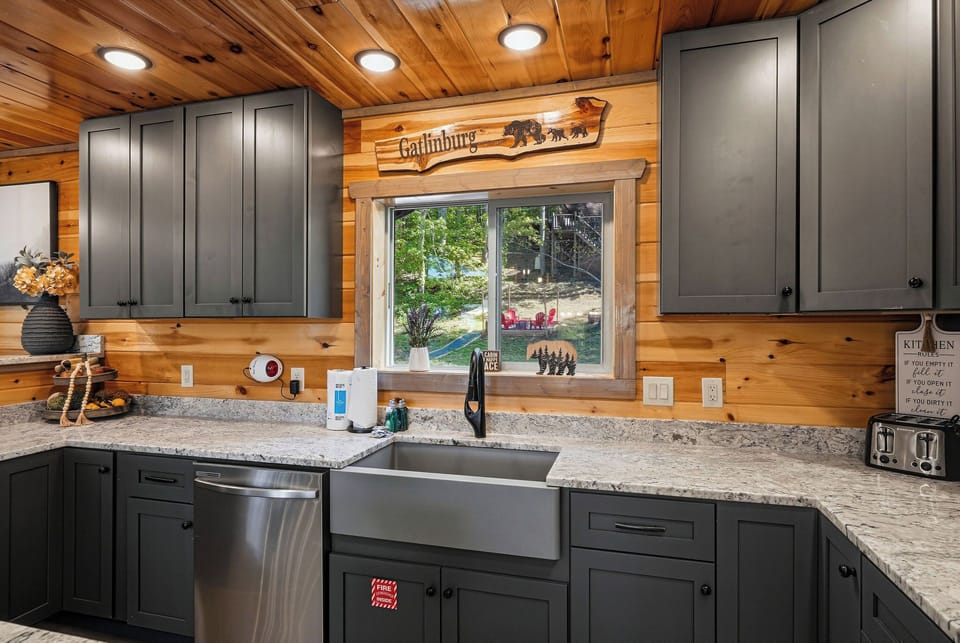Prepare your favorite meals in this fully equipped kitchen featuring granite counters, stainless appliances, and charming log cabin details.