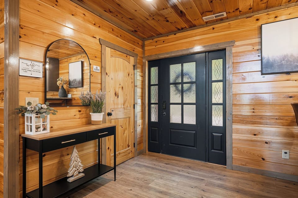 Step into your cozy mountain retreat through elegant French doors, where rustic log walls and thoughtful touches create an instantly welcoming atmosphere.