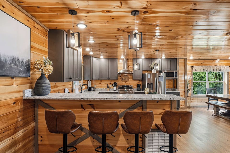 Your rustic kitchen awaits with modern appliances, granite counters, and cozy seating where you'll gather for morning coffee and evening conversations.