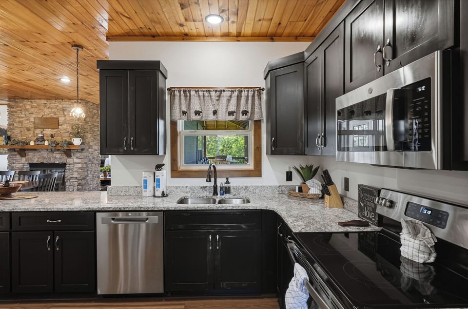 Cook your favorite meals in this fully equipped kitchen with sleek granite counters, stainless steel appliances, and warm wood-beam ceilings inviting you to gather and create.