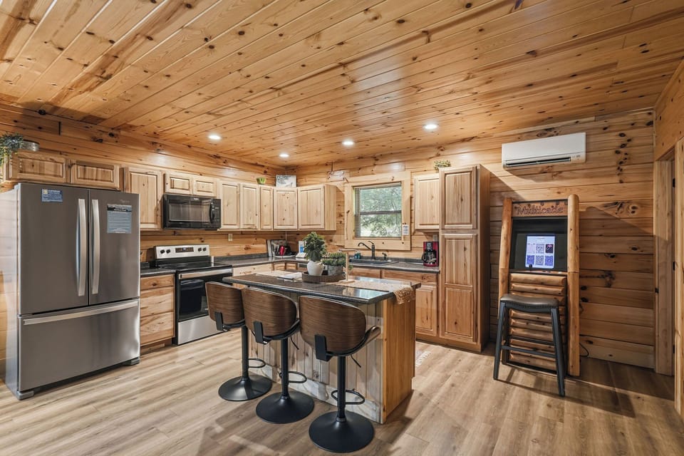 Gather around the spacious kitchen island with stainless steel appliances, granite countertops, and warm knotty pine finishes welcoming you to cook, share meals, and create lasting memories in this cozy mountain retreat.