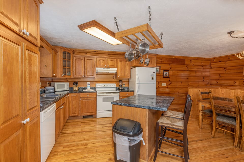 Full kitchen with island and hanging pots from ceiling