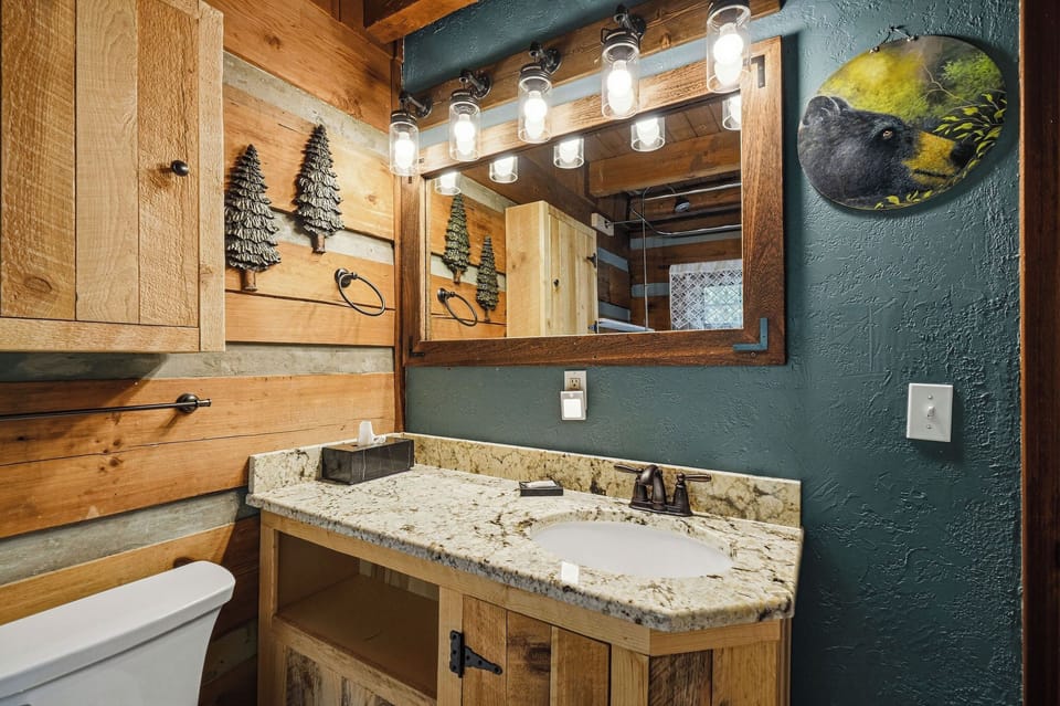 Step into your private bathroom featuring rustic wood accents, granite countertops, and charming cabin-inspired décor that brings mountain serenity to your morning routine.