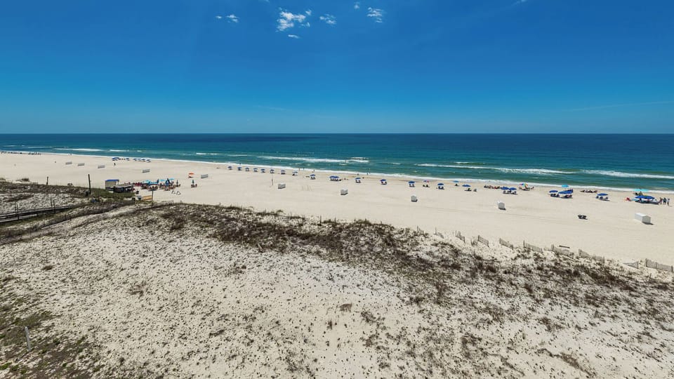 Bright blue sky meets endless turquoise water as you stroll along the peaceful beach coast