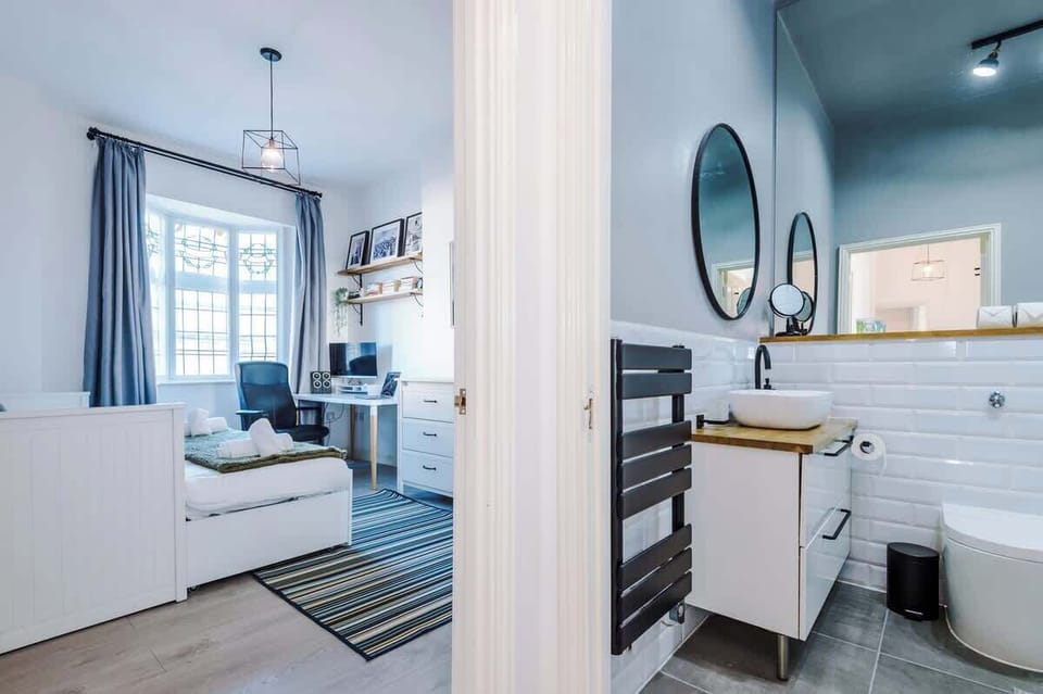 The bathroom is located just off the hallway next to the second bedroom.