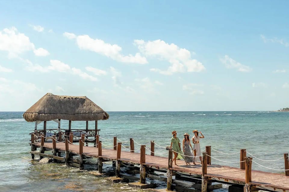 Beach pier tranquility: stroll beside vibrant club, enjoy waves at water's edge.