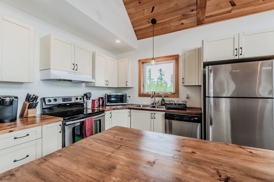 The kitchen boasts wooden countertops and stainless steel appliances, providing a stylish and functional space for cooking.