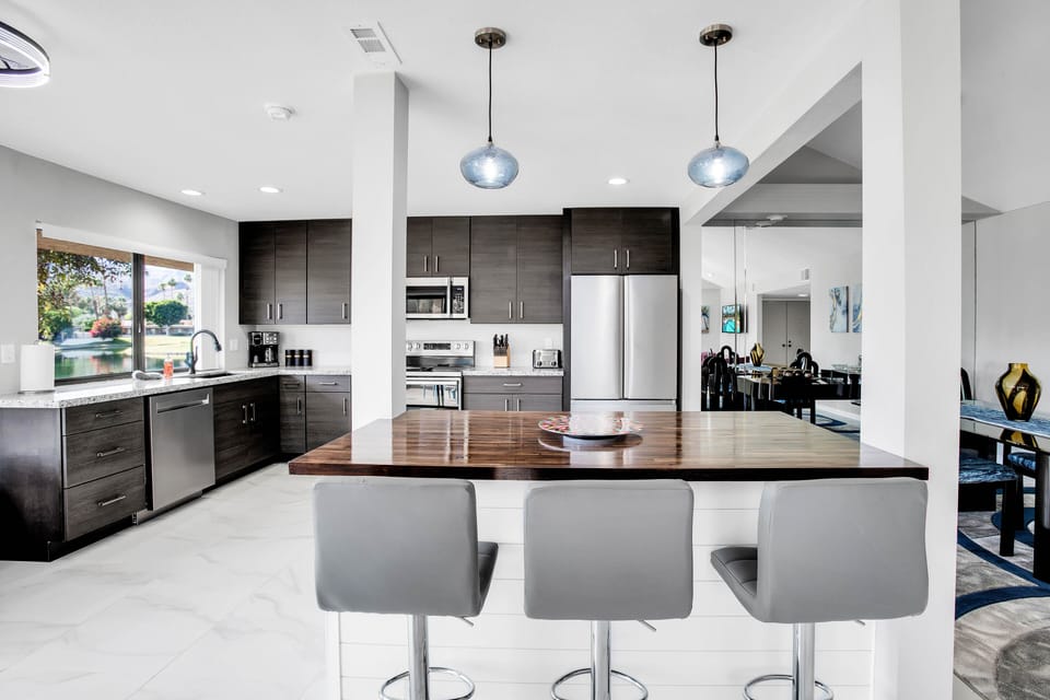 Modern kitchen with large island, bar seating, and stainless appliances
